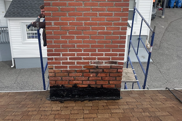 Brick Chimney Undergoing Repair on Rooftop Scaffolding